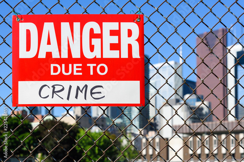  Sign danger due to crime hanging on the fence