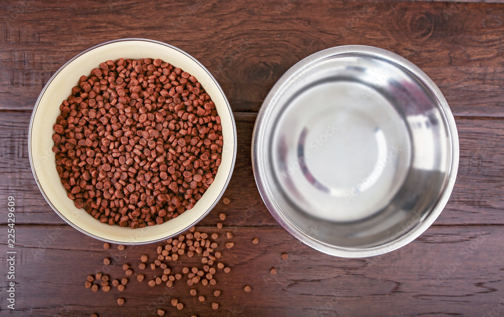 metal bowls full of dog food and water on a wooden floor isolated on a white background overhead studio shot metal bowls full of dog food and water on a wooden floor isolated on a white background overhead studio shot
