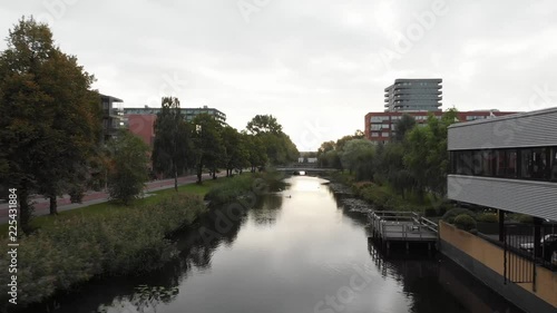 Geuzenveld-Slotermeer in Amsterdam, The Netherlands, during the sunrise while the drone flies forward over the river. photo