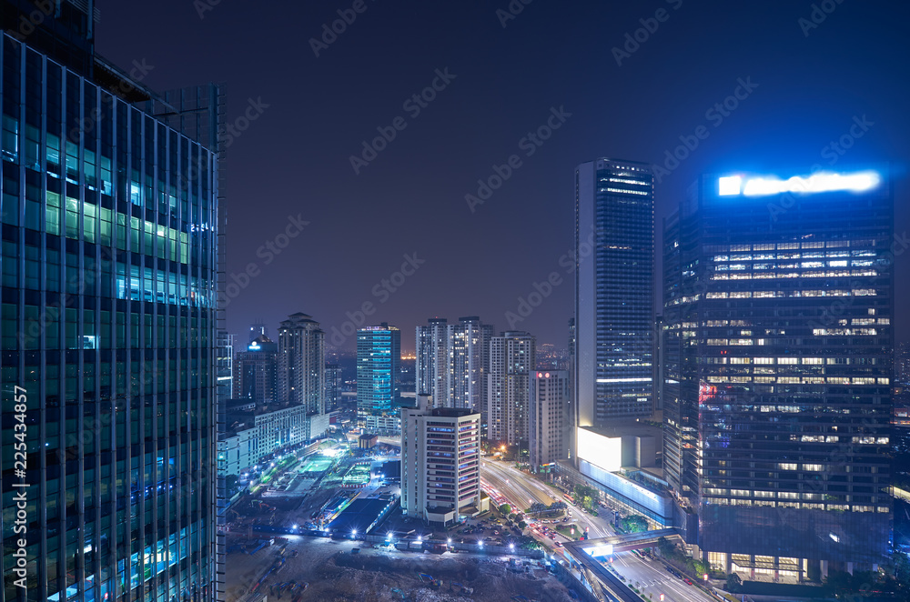 Modern office building in urban city at the night with beautiful city skyline view .