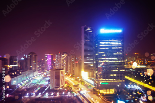 Modern illuminated office urbanscape at the night with abstract bokeh effect . Selected focusing depth of field effect apply.