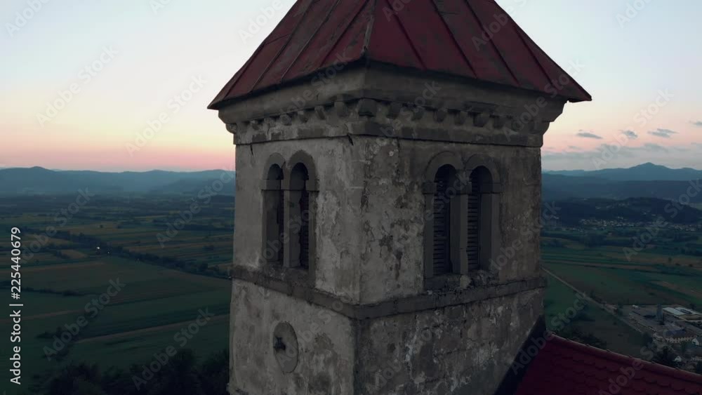 Aerial close up shoot of a old catholic church on a hill with a beautifull view to the village in summer time in sunset. Aerial view. Landscape. Nature. 4K. Morning sunrise. Slovenia Aerial close up shoot of a old catholic church on a hill with a beautifull view to the village in summer time in sunset. Aerial view. Landscape. Nature. 4K. Morning sunrise. Slovenia