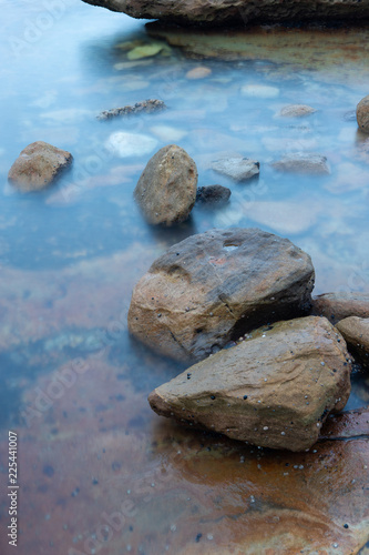 Rock and still water under an overcast day light.