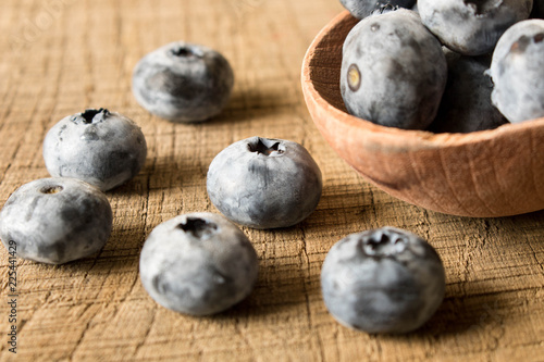 Fresh blueberries in a wooden spoon. On an old wooden table. The concept of natural food . Close up