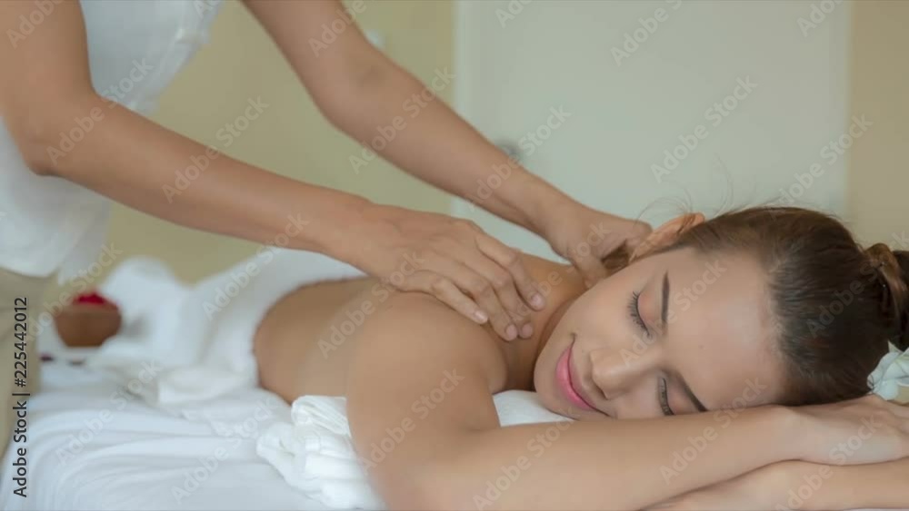 Young asian woman receiving a massage in modern spa treatment place. Young asian woman receiving a massage in modern spa treatment place.