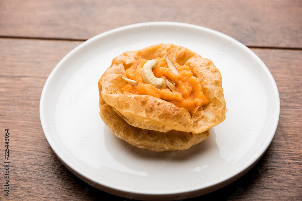 Suji/Sooji Halwa Puri or Shira Poori breakfast, served in a plate and bowl. selective focus Suji/Sooji Halwa Puri or Shira Poori breakfast, served in a plate and bowl. selective focus