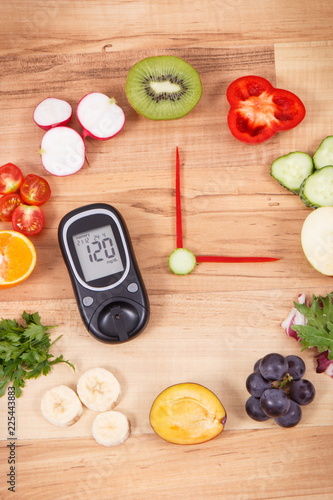 Glucometer with sugar level and clock made of fruits with vegetables, healthy lifestyle of diabetics concept