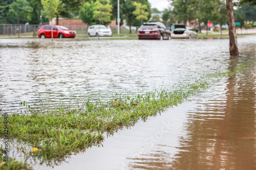 Canvas Print Stormwater flooding a road with stalled cars in the background