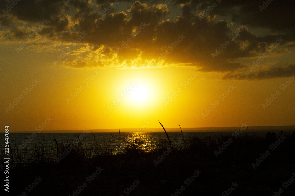 Sunset on the sea on the beach. Bright yellow sunset. The wave on the beach at sunset. Sunset on the sea on the beach. Bright yellow sunset. The wave on the beach at sunset.
