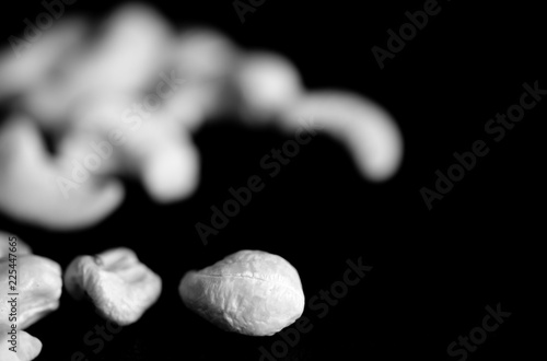 Cashew nuts on a dark background close up. Black and white