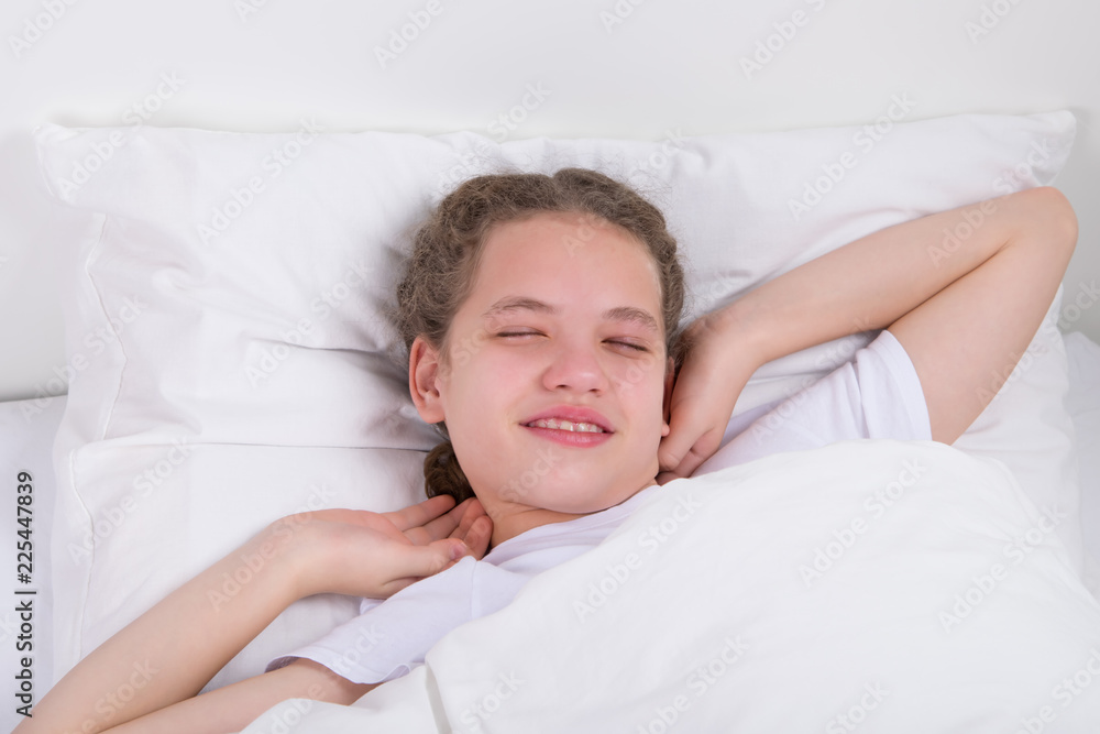 a sleepy girl in bed, opens her eyes and pulls herself to the side to wake up a sleepy girl in bed, opens her eyes and pulls herself to the side to wake up
