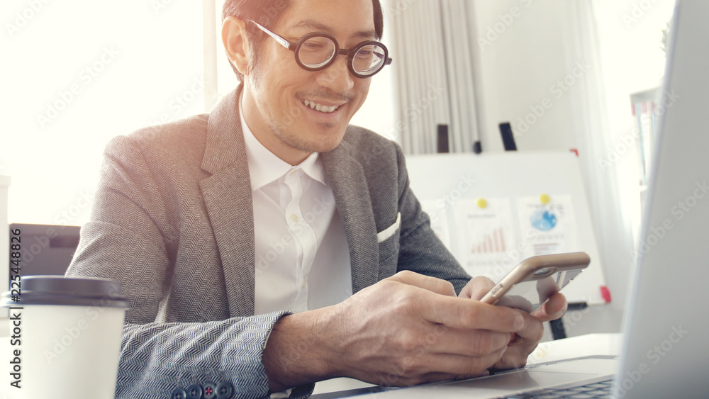 Business man in office using laptop and cell phone, Business man in office using laptop and cell phone,