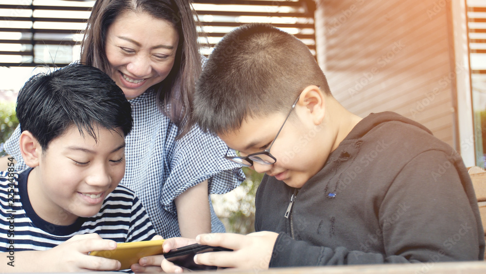 Asian family mother and son watching on mobile phone. Asian family mother and son watching on mobile phone.