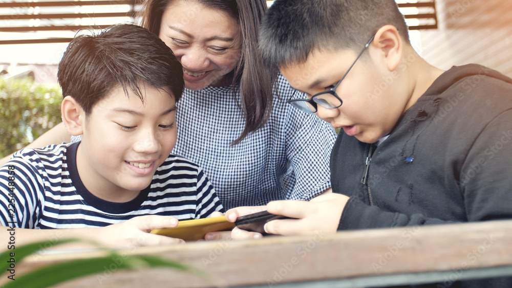 Asian family mother and son watching on mobile phone. Asian family mother and son watching on mobile phone.