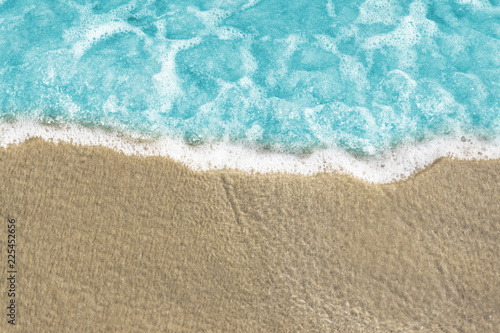 Fototapeta Naklejka Na Ścianę i Meble -  Soft wave of blue ocean on sandy beach. Background / Sand and wave at the beach background. Drop space on bottom for text and other.