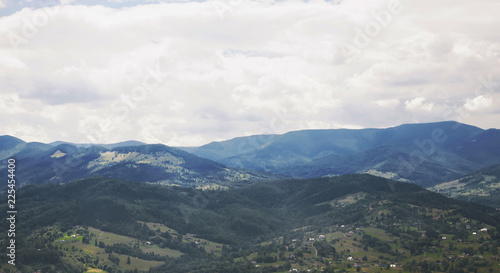 Mountain valley village landscape. Cloudy sky