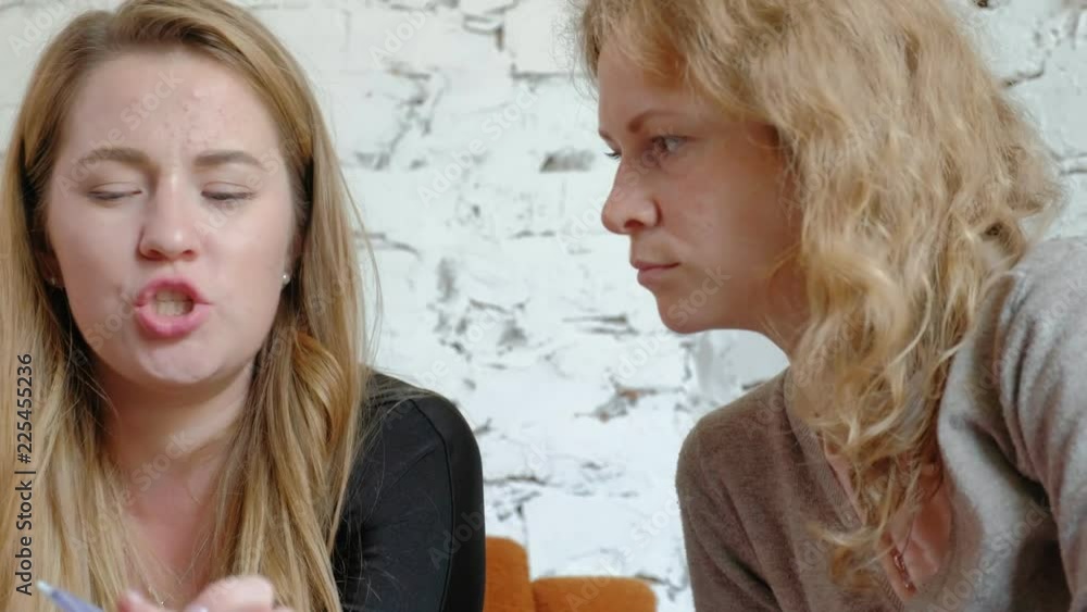 Two business women using a touchpad in the office are busy discussing matters Two business women using a touchpad in the office are busy discussing matters