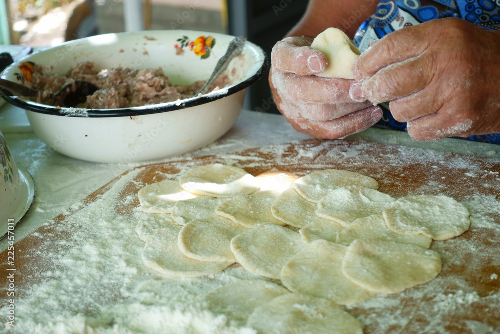 Fototapeta premium Home-made recipe for dumplings (raviol)i. Traditionally, women of the older generation mold the dumplings in the family.