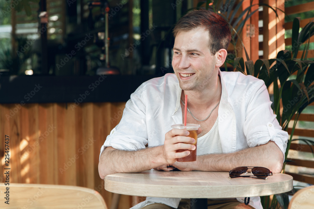 Cute student businessman joyful and happy in the cafe in the park. Cute student businessman joyful and happy in the cafe in the park.
