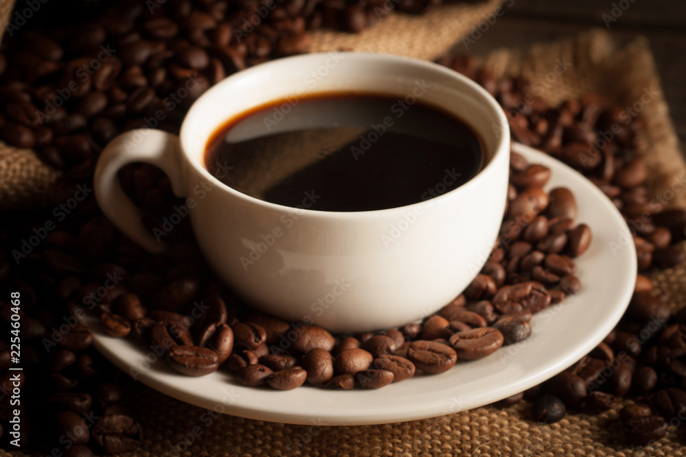 Coffee cup and beans on a rustic background. Coffee Espresso and a piece of cake with a curl. Cup of Coffee and coffee beans on table. Coffee cup and beans on a rustic background. Coffee Espresso and a piece of cake with a curl. Cup of Coffee and coffee beans on table.
