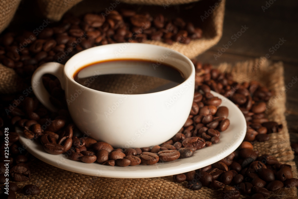 Coffee cup and beans on a rustic background. Coffee Espresso and a piece of cake with a curl. Cup of Coffee and coffee beans on table. Coffee cup and beans on a rustic background. Coffee Espresso and a piece of cake with a curl. Cup of Coffee and coffee beans on table.