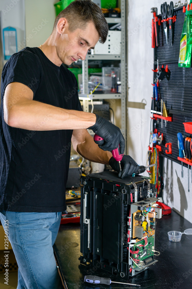 Hardware repairman repairing broken printer fax machine Hardware repairman repairing broken printer fax machine