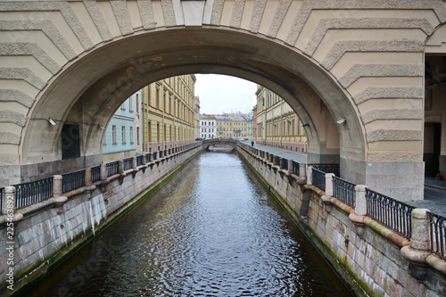 Water channel under the arch of whose banks are lined with old granite fence. St. Petersburg, Russia, Europe