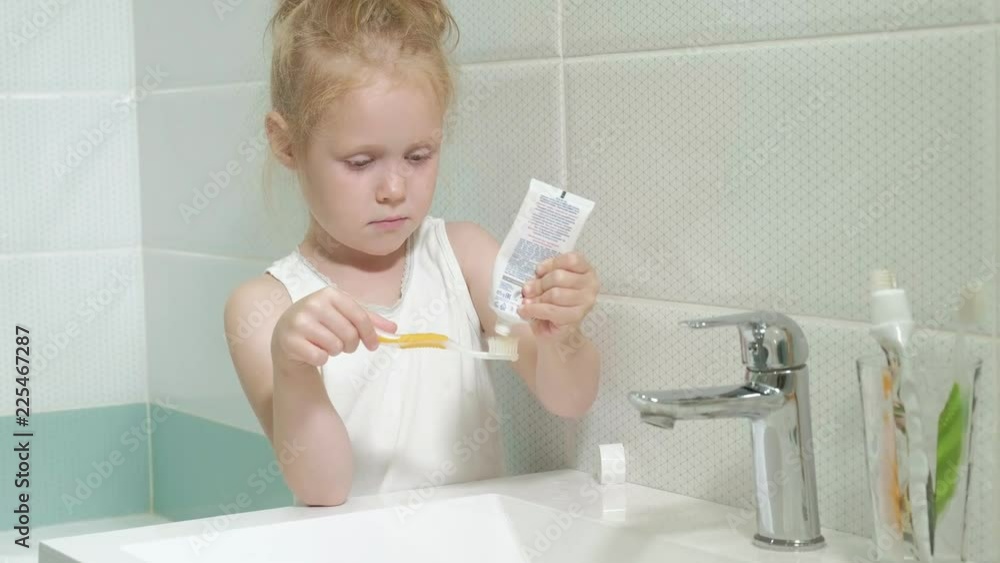 Little girl diligently brushing his teeth in the mirror. Little girl diligently brushing his teeth in the mirror.