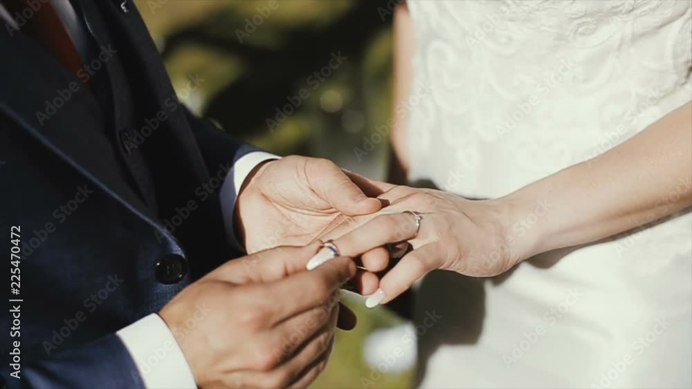 The groom puts the wedding ring on finger of the bride. marriage. hands with rings. The bride and groom exchange wedding rings. The groom puts the wedding ring on finger of the bride. marriage. hands with rings. The bride and groom exchange wedding rings.