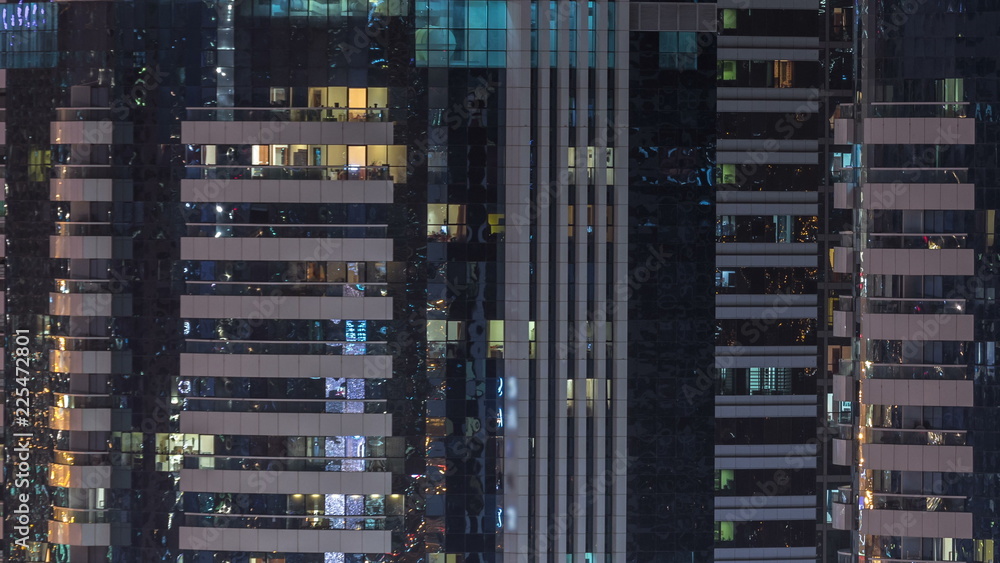 Windows of the multi-storey building of glass and steel lighting inside and moving people within timelapse Windows of the multi-storey building of glass and steel lighting inside and moving people within timelapse