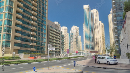 Dubai Marina with Skyscrapers timelapse and traffic on the street near concrete road bridge through the canal