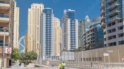 Dubai Marina with Skyscrapers timelapse and traffic on the street near concrete road bridge through the canal