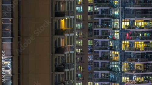Windows of the multi-storey building of glass and steel lighting inside and moving people within timelapse © neiezhmakov