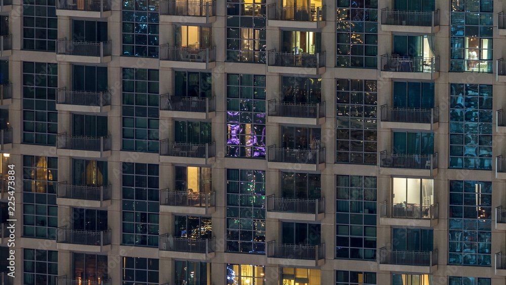Windows of the multi-storey building of glass and steel lighting inside and moving people within timelapse Windows of the multi-storey building of glass and steel lighting inside and moving people within timelapse