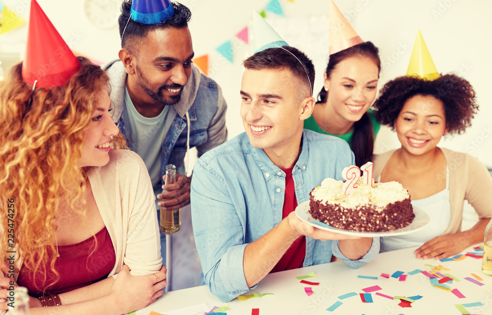 corporate party and people concept - happy team with cake and non-alcoholic drinks celebrating colleague 21st birthday at office corporate party and people concept - happy team with cake and non-alcoholic drinks celebrating colleague 21st birthday at office