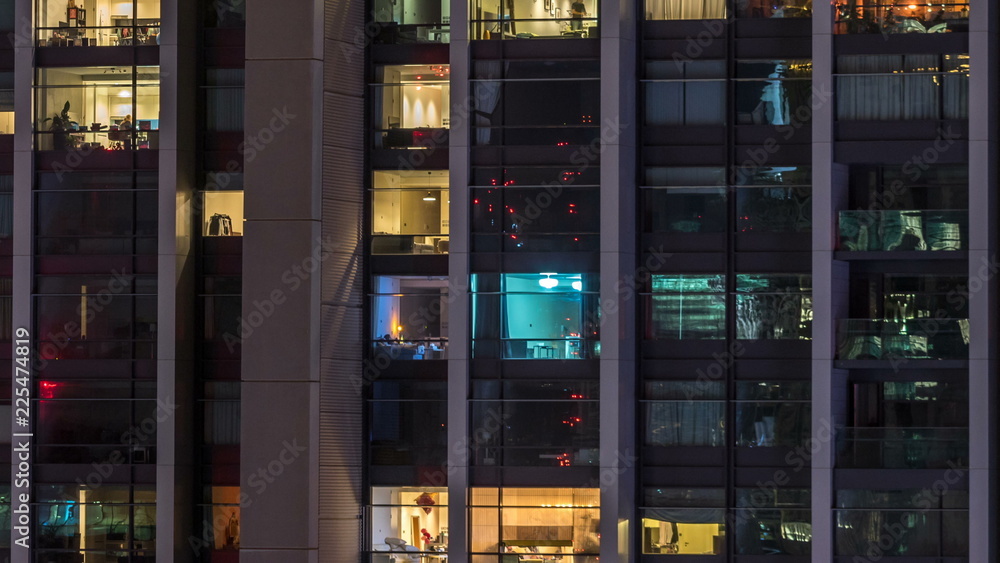 Windows of the multi-storey building of glass and steel lighting inside and moving people within timelapse Windows of the multi-storey building of glass and steel lighting inside and moving people within timelapse