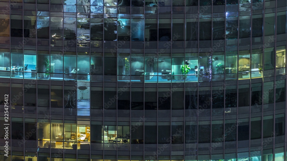 Windows of the multi-storey building of glass and steel lighting inside and moving people within timelapse Windows of the multi-storey building of glass and steel lighting inside and moving people within timelapse