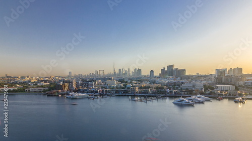 Dubai creek landscape timelapse with boats and ship and modern buildings in the background during sunset