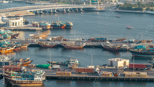 Dubai creek landscape timelapse with boats and ship in port and modern buildings in the background during sunset photo