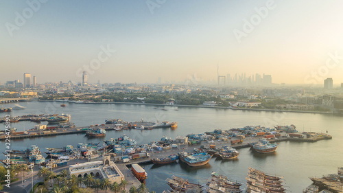 Dubai creek landscape timelapse with boats and ship in port and modern buildings in the background during sunset photo