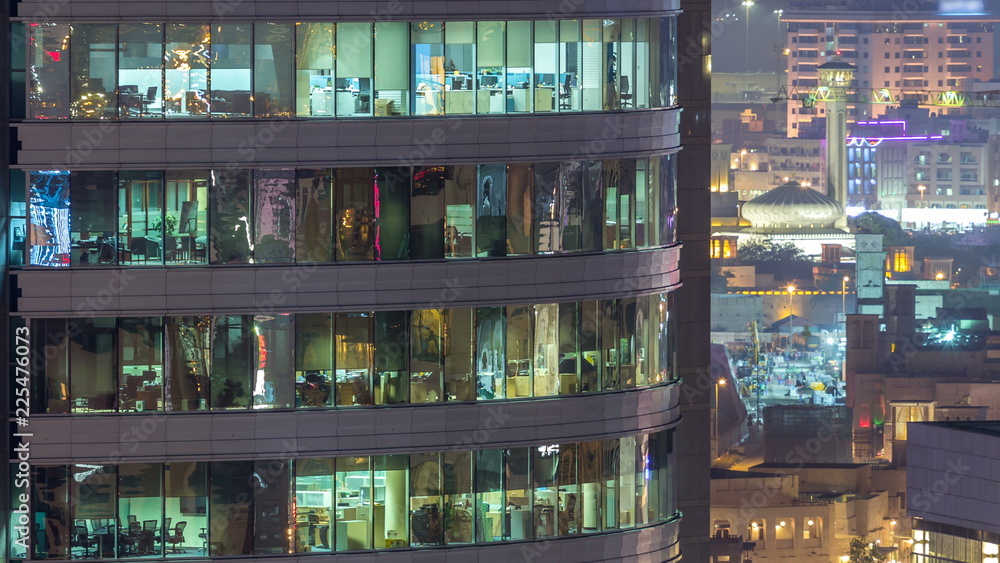 Windows of the multi-storey building of glass and steel lighting inside and moving people within timelapse Windows of the multi-storey building of glass and steel lighting inside and moving people within timelapse