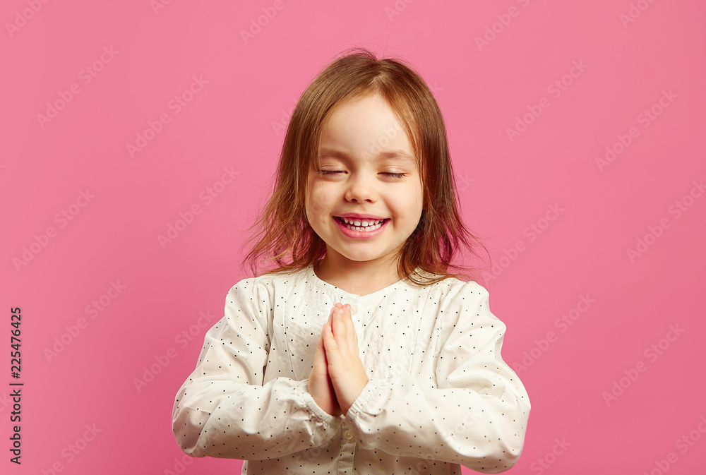 Little girl folded her hands in palms, closed eyes, prays or makes a wish, wants something very much. Little girl folded her hands in palms, closed eyes, prays or makes a wish, wants something very much.
