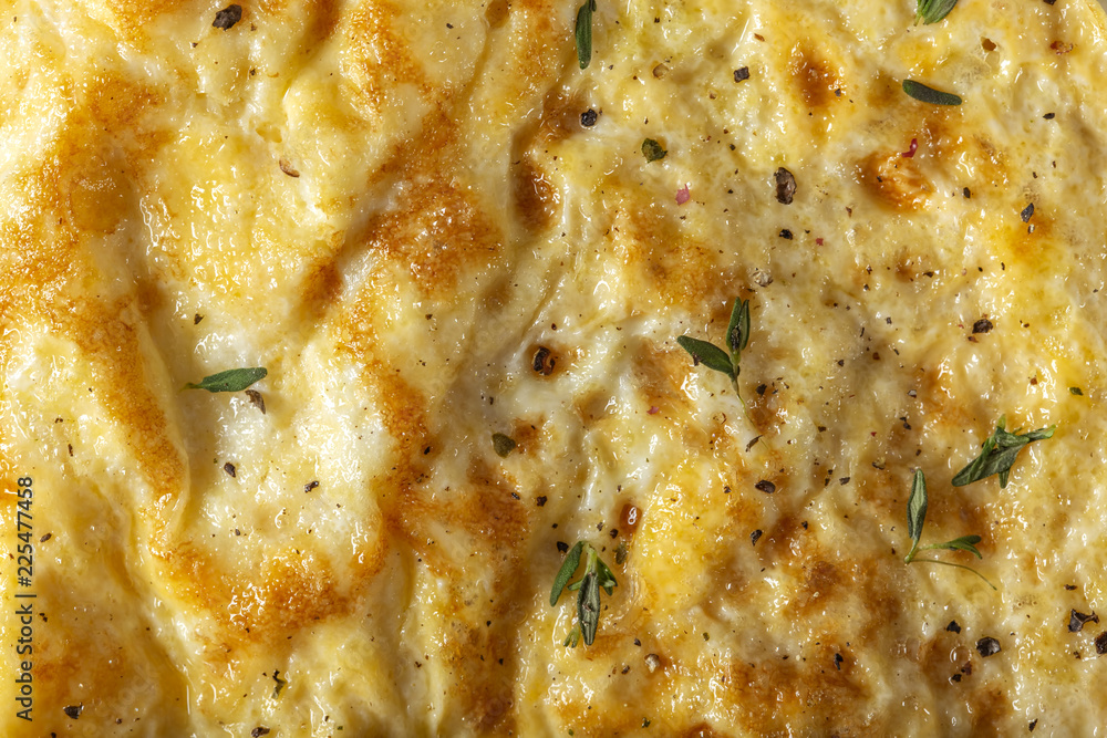 Scrambled eggs or omelette made from eggs and cheese with herbs on the plate Scrambled eggs or omelette made from eggs and cheese with herbs on the plate