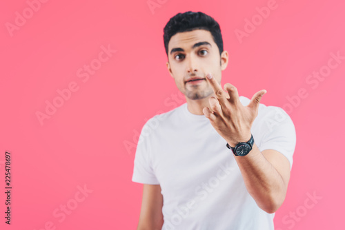 selective focus of irritated man showing middle finger isolated on pink
