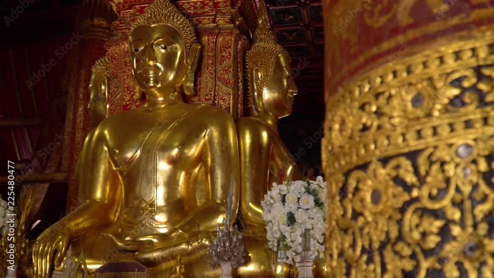 Ancient large gilded Buddhas seated on a raised platform inside Wat Phumin Temple.The most attractive temple in the town of Nan province at Thailand Ancient large gilded Buddhas seated on a raised platform inside Wat Phumin Temple.The most attractive temple in the town of Nan province at Thailand