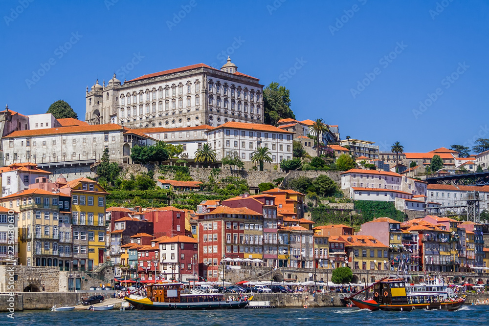 Porto or Oporto, Portugal. Ribeira District with typical colorful buildings, the Douro River and cruise ships for tourists in of Rabelo boats shape
