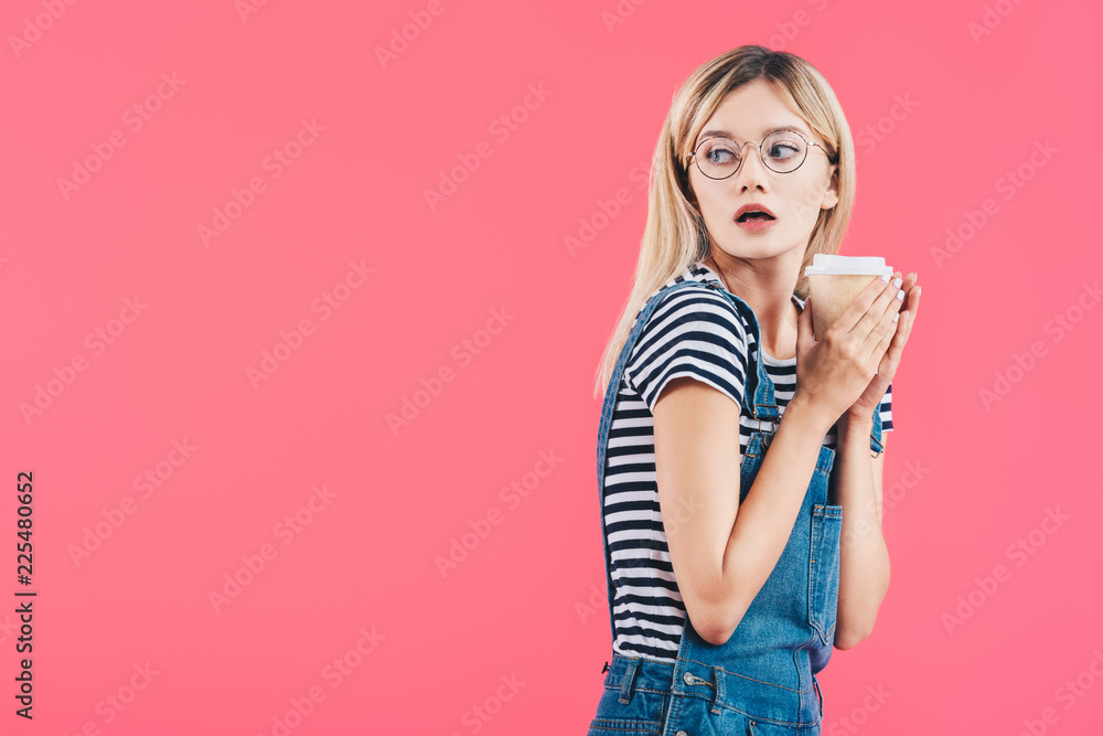 side view of shocked young woman with coffee to go isolated on pink side view of shocked young woman with coffee to go isolated on pink