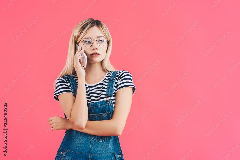 portrait of young pensive woman talking on smartphone isolated on pink portrait of young pensive woman talking on smartphone isolated on pink