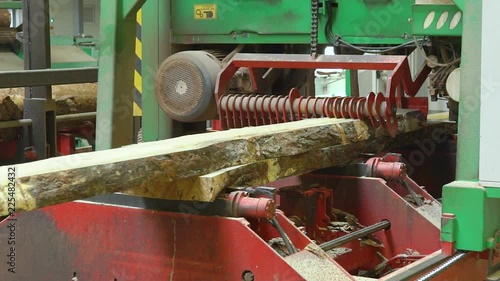 Machine-tool, woodworking machine cuts sawing log, timber, lumber, makes plank. Saw cutting. Production process at a wood processing plant