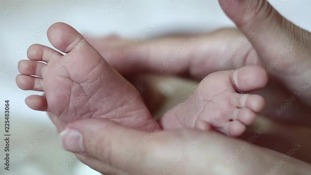 Hands of mother with little baby feet. One months old baby boy. Mom holds little baby feet in the hands Hands of mother with little baby feet. One months old baby boy. Mom holds little baby feet in the hands